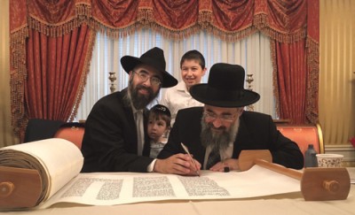 The new kehilla’s rav, Rabbi Refael Ribacoff, his sons Avner Shmuel (left) and Moshe Ovadiya, and Rav Yitzchak Yisraeli completing the sefer Torah.